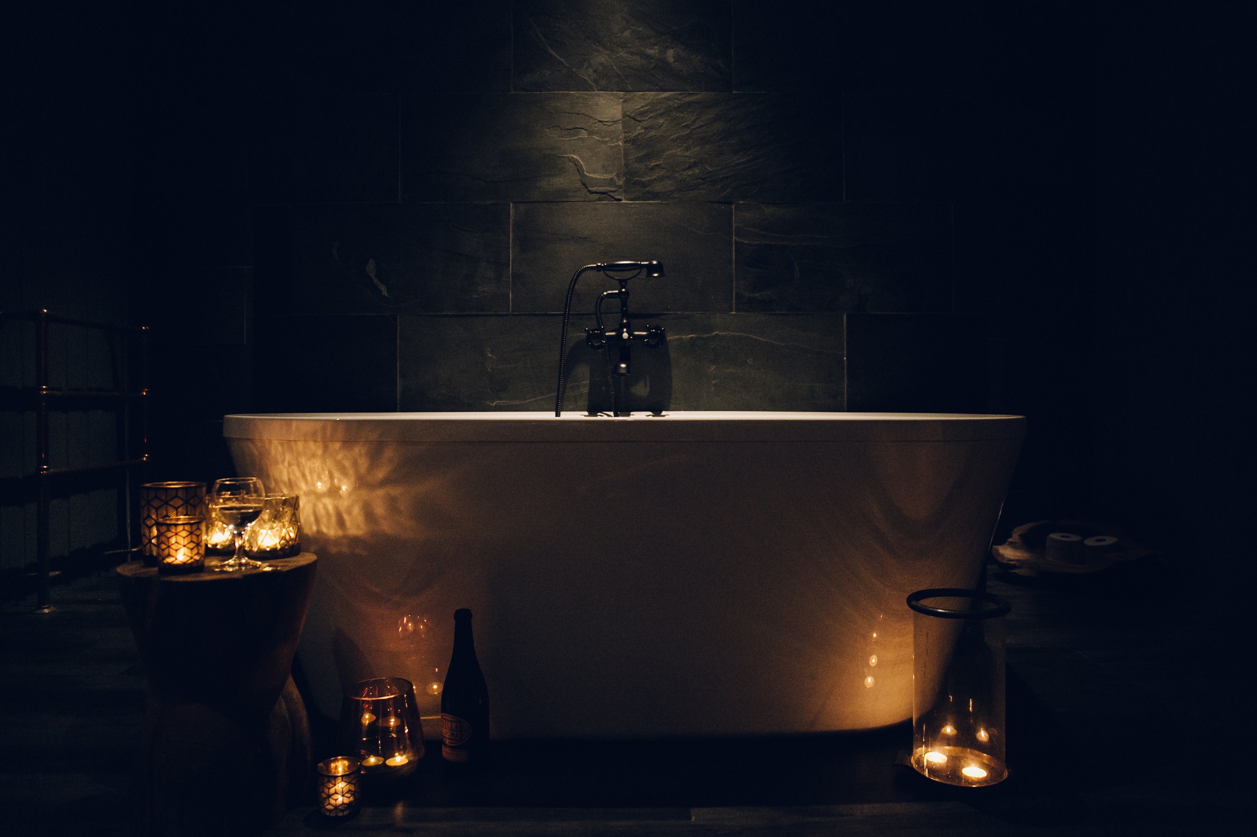 A bath surrounded by candles and lanterns